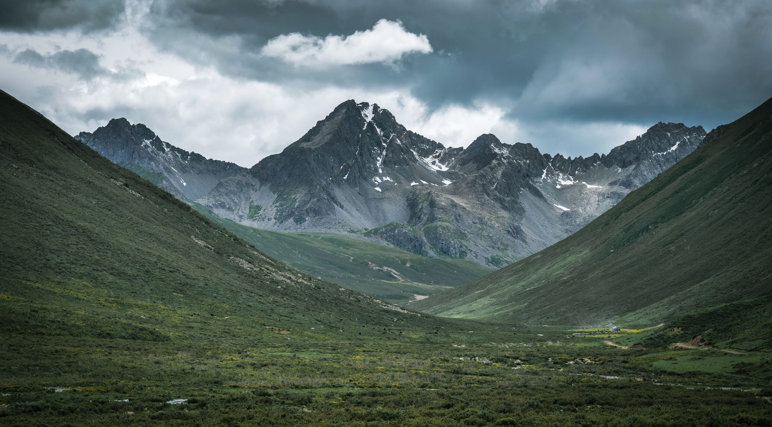 Stunning view of a remote mountain range under dramatic cloudy sky, perfect for nature lovers.